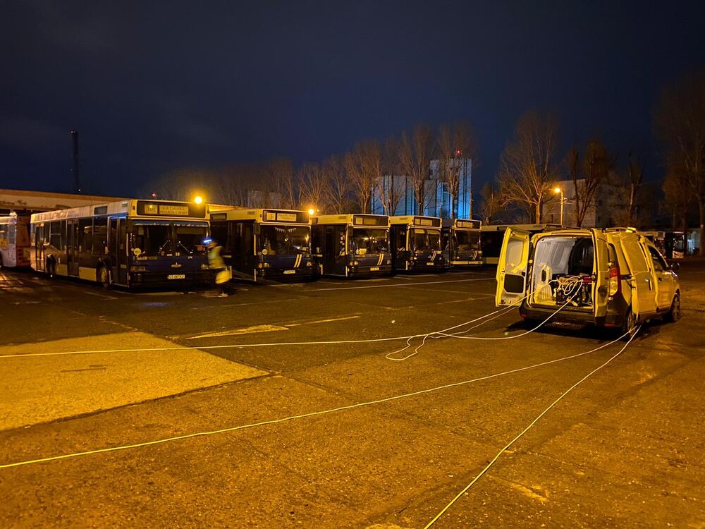 Flota de autobuze CT Bus Constanța, aliniată noaptea în depou, cu autoutilitara Compania DDD între ele