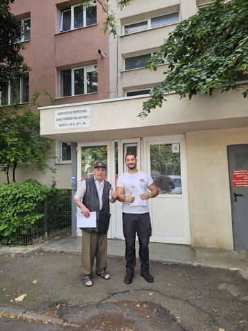 Operator Compania DDD la intrarea unui bloc, cu procesul-verbal semnat de reprezentantul asociației