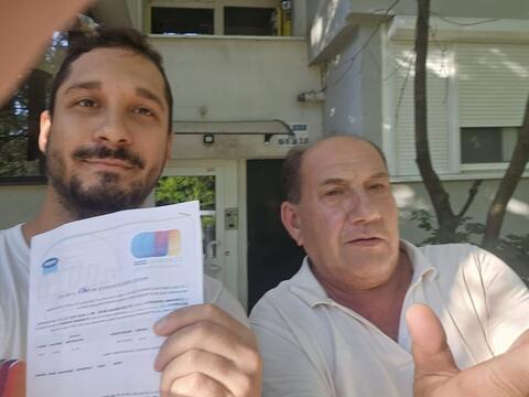 Operator Compania DDD la intrarea unui bloc, cu procesul-verbal semnat de reprezentantul asociației