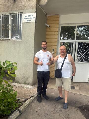 Operator Compania DDD la intrarea unui bloc, cu procesul-verbal semnat de reprezentantul asociației