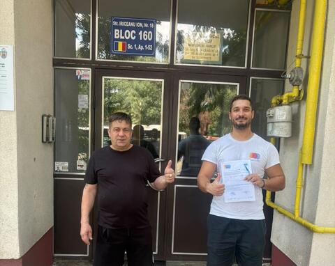 Operator Compania DDD la intrarea unui bloc, cu procesul-verbal semnat de reprezentantul asociației