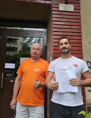 Operator Compania DDD la intrarea unui bloc, cu procesul-verbal semnat de reprezentantul asociației