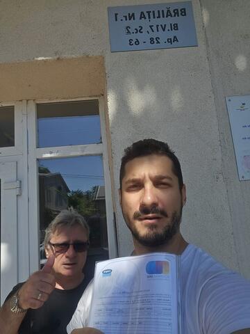 Operator Compania DDD la intrarea unui bloc, cu procesul-verbal semnat de reprezentantul asociației