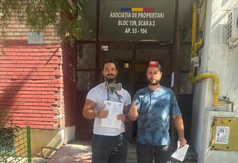Operator Compania DDD la intrarea unui bloc, cu procesul-verbal semnat de reprezentantul asociației