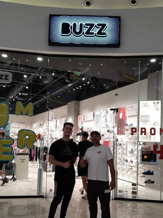 Operator Compania DDD și un angajat al magazinului BUZZ, în fața intrării