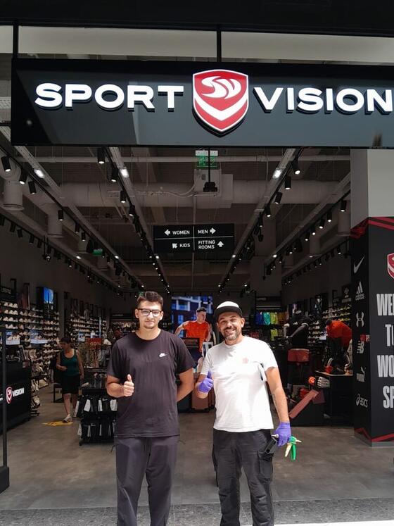 Coleg Compania DDD cu mănuși de protecție și echipamentul în mână, alături de un angajat Sport Vision